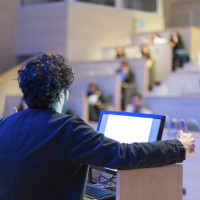 Speaker giving talk on podium at Business Conference. Business and Entrepreneurship. Expert presenting his work in lectures hall.